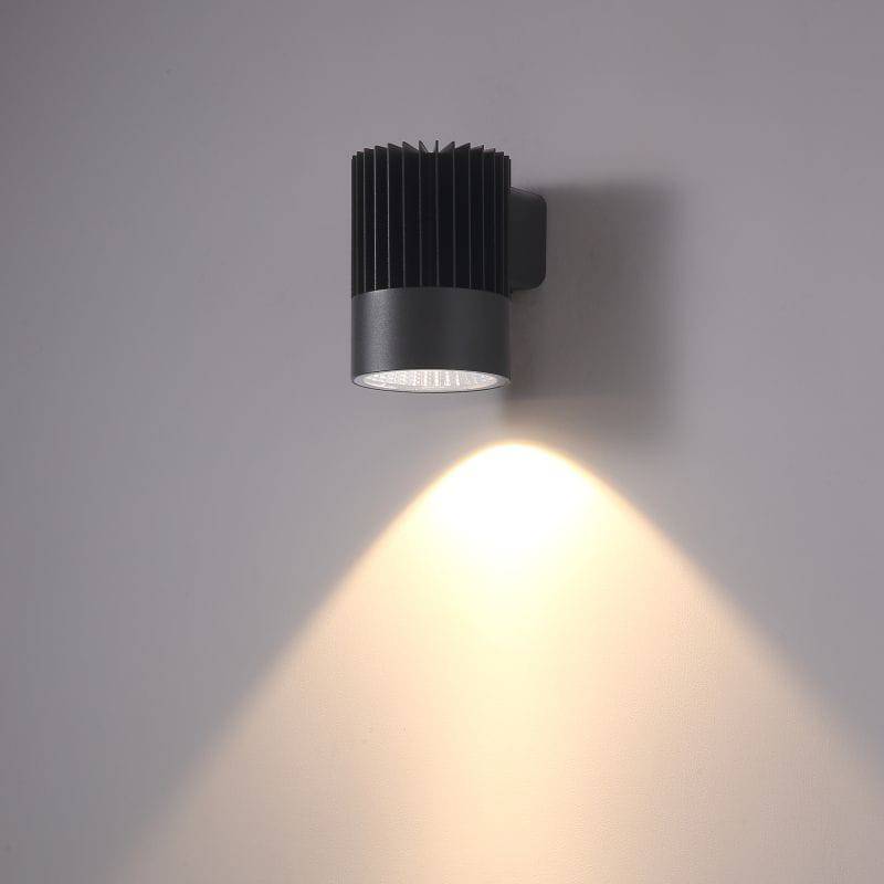 black large outdoor wall downlight shown mounted on a white wall 