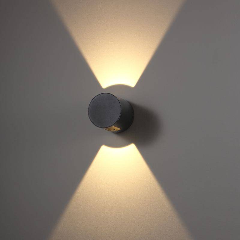 black outdoor up down wall light installed on a white wall