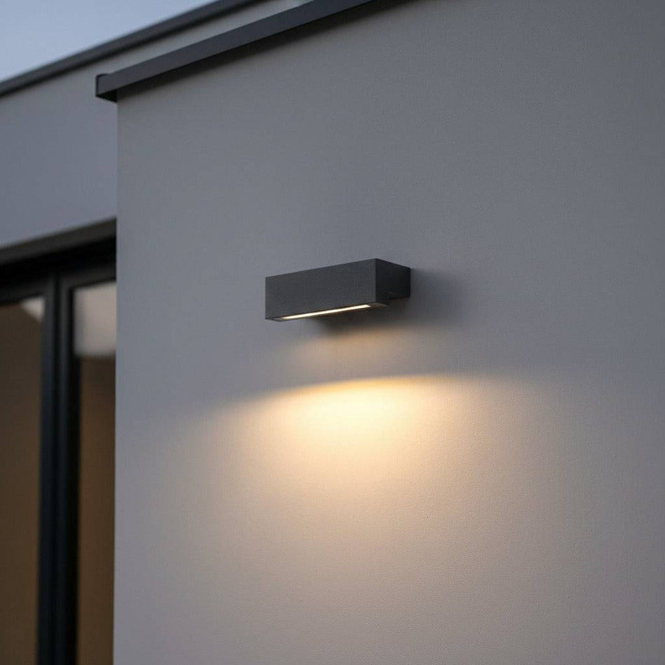 black outdoor down wall light mounted on a white painted wall outside a modern house 