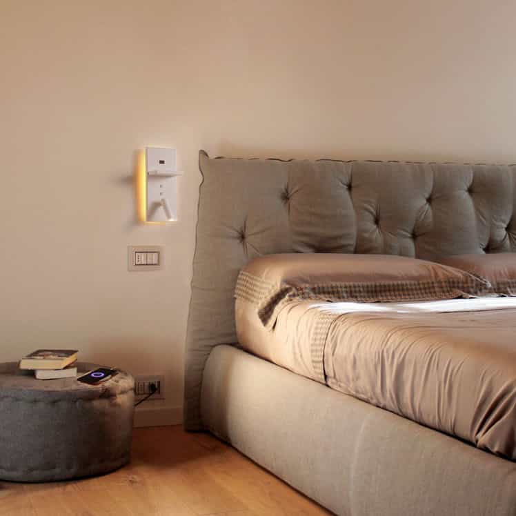 white bedroom wall light with reading light mounted on the wall next to a bed for reading
