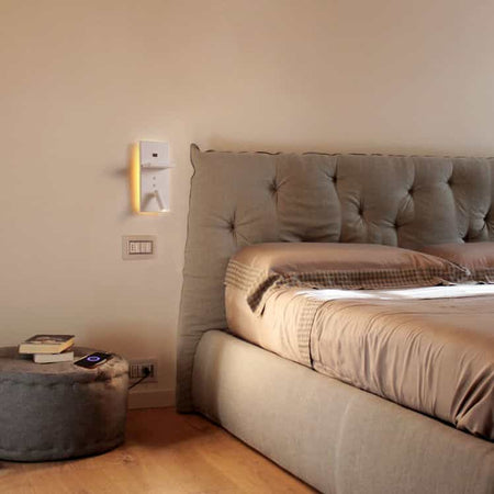 white bedroom wall light with reading light mounted on the wall next to a bed for reading
