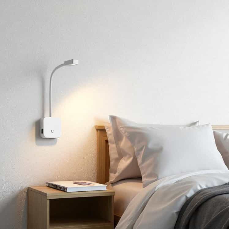 white bedroom reading lamp with USB ports installed on the wall next to the bed in a modern bedroom