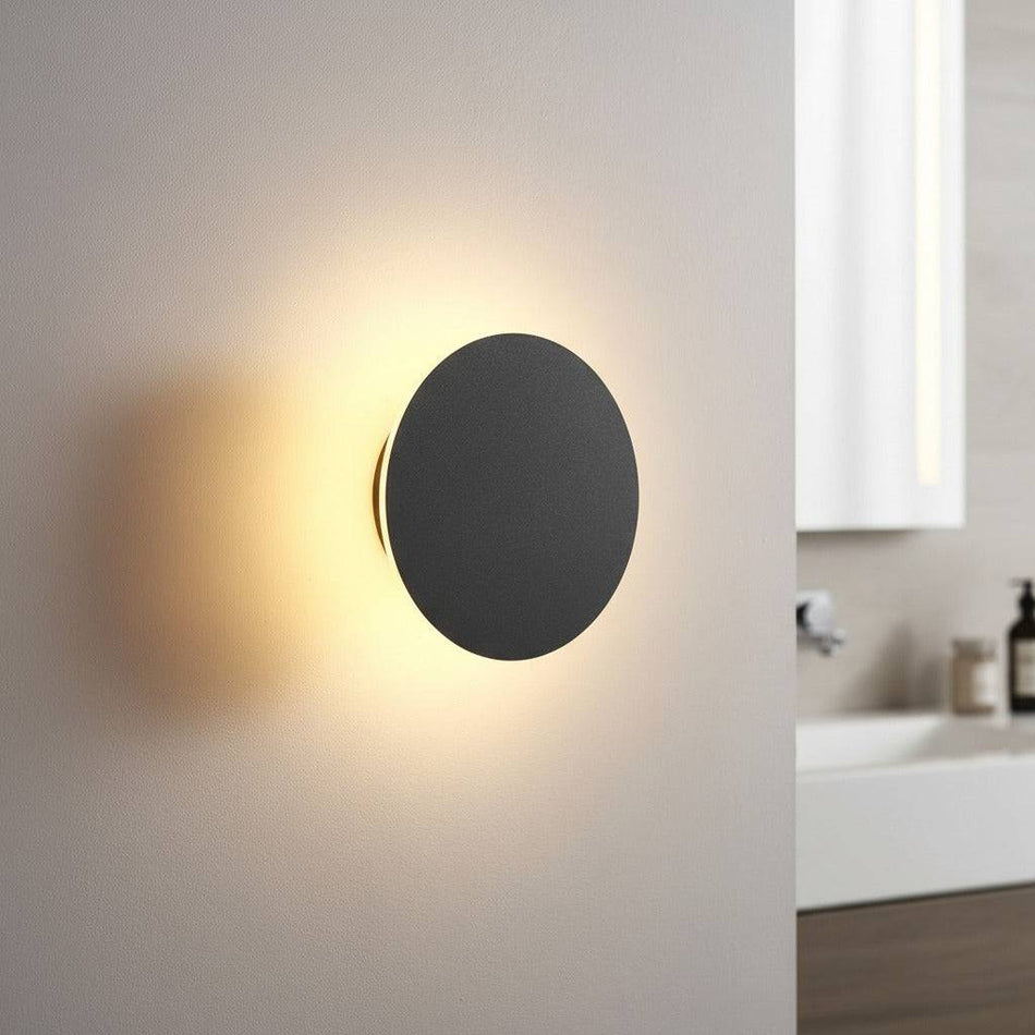 black bathroom sconce mounted on the wall in a modern bathroom