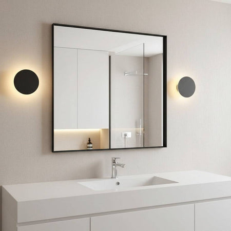 black bathroom sconce mounted either side of the mirror in a modern bathroom