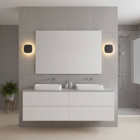black vanity wall light shown mounted either side of a bathroom mirror in a modern bathroom