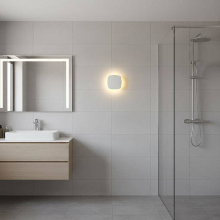 white bathroom wall mount light fixture mounted on the wall in a modern bathroom 
