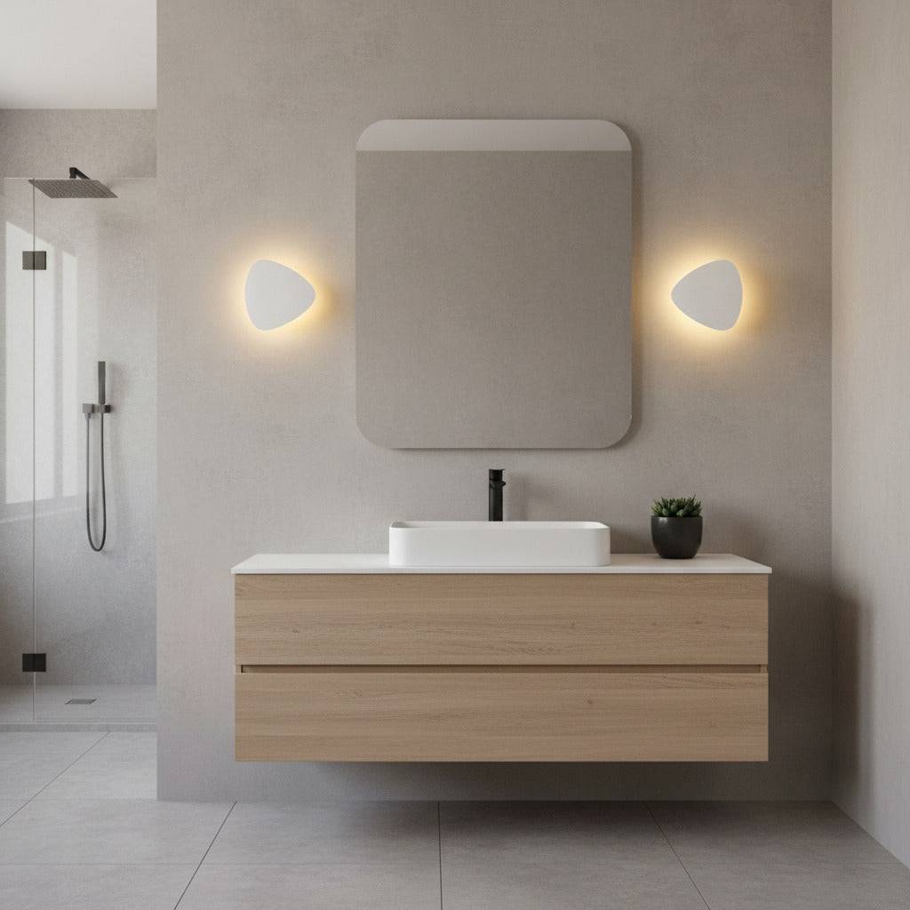 white wall mounted vanity light mounted either side of the mirror in a modern bathroom 