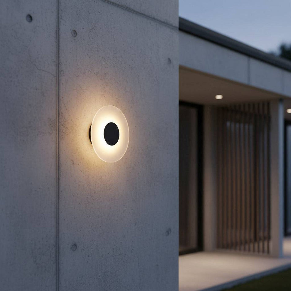 black wall outdoor lamp mounted on the concrete exterior wall of a modern home