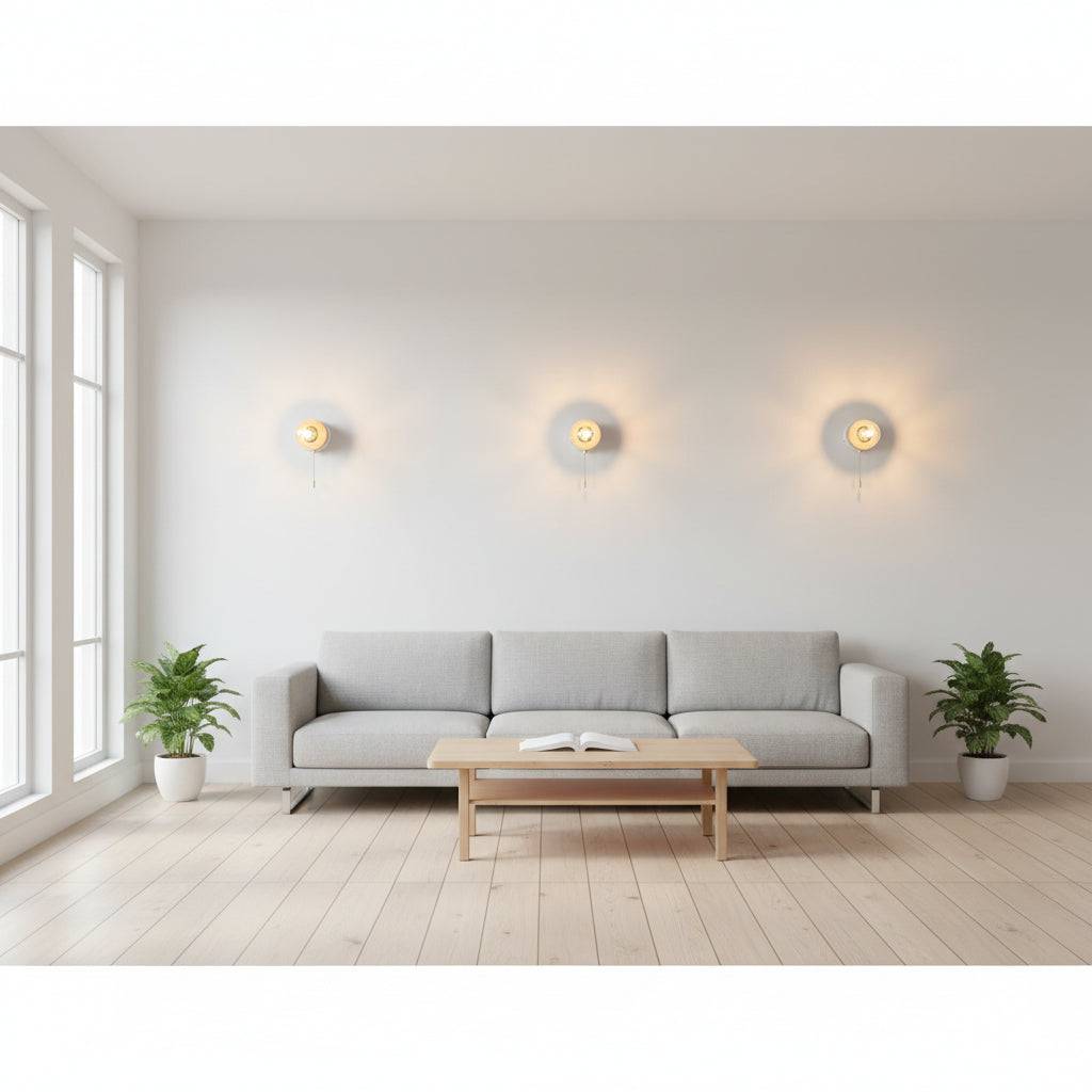 White interior LED wall light with pull cord three lights mounted on a pale coloured wall in a lounge area