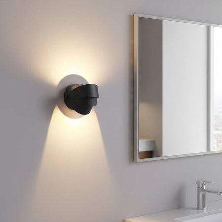 black vanity sconce light mounted on the wall in a modern bathroom next to the mirror 