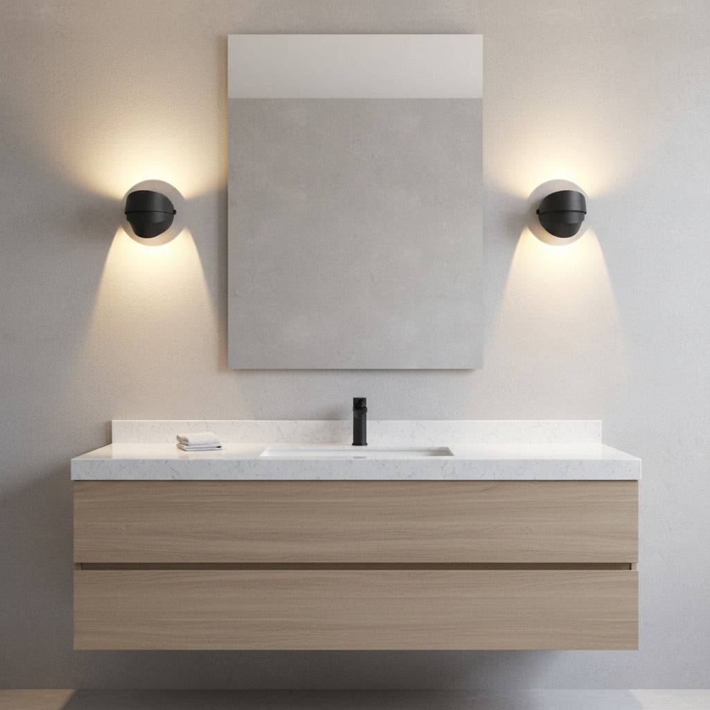 black vanity sconce light mounted either side of a mirror in a modern bathroom 