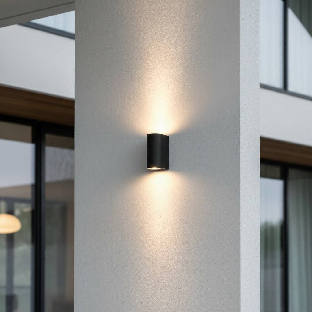 black outdoor up down light mounted on a white wall outside a modern home