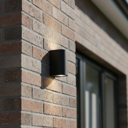 black outdoor up down light installed on a brick wall 