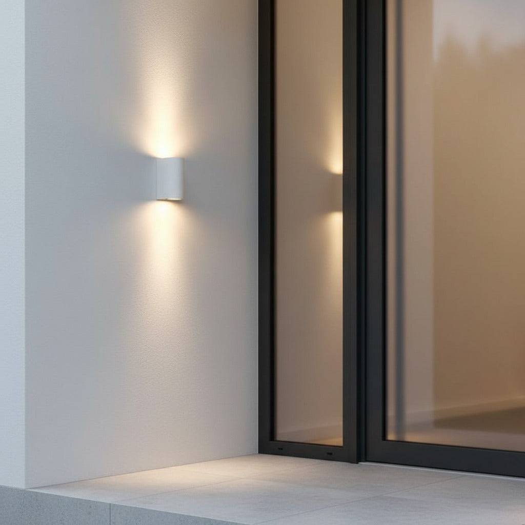 white up and down outside wall light mounted on the wall next to the door of a modern home