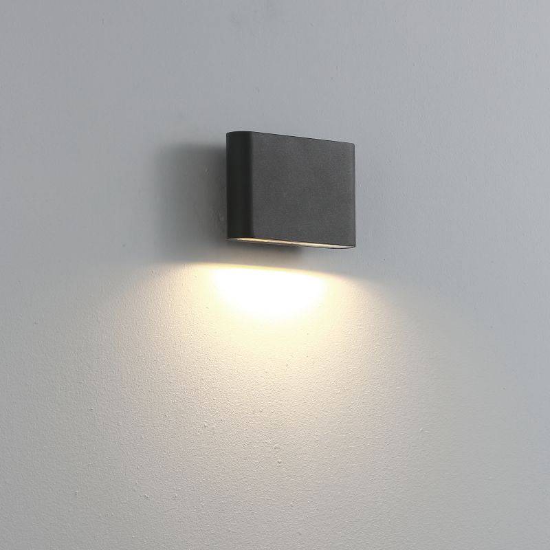 black outdoor LED wall downlight mounted on a white wall 
