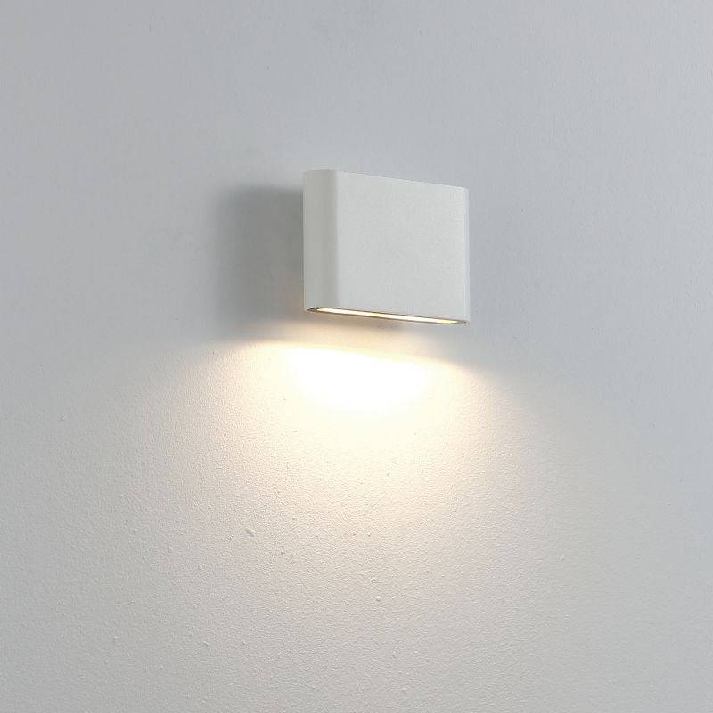 white vanity wall light fixture mounted on a white wall 