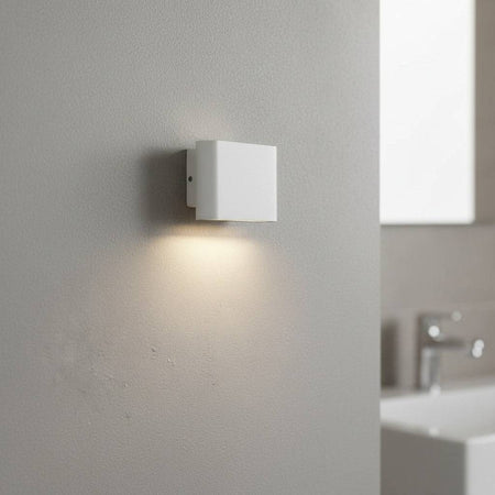 white vanity wall light fixture mounted on the wall in a modern bathroom 
