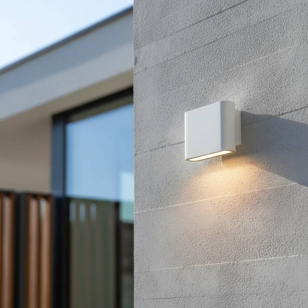 White outside wall downlight mounted on a concrete wall on the exterior of a modern home