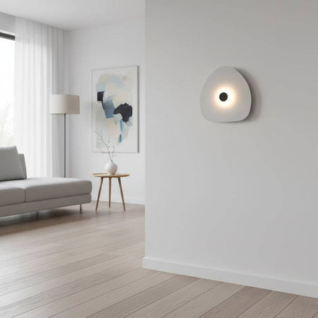 Modern internal wall light with a white finish and a black central halo on a wall within  a modern lounge