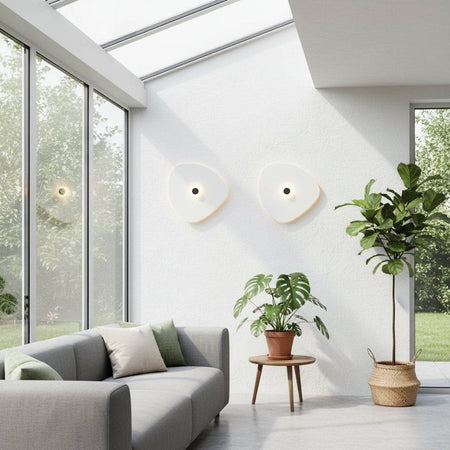 White indoor decorative wall sconce with a black centre where the light emits situated in a conservatory
