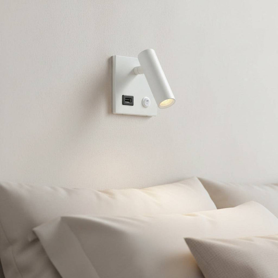 white recessed bedside reading lamp with USB port mounted over a bed on the wall in a modern bedroom
