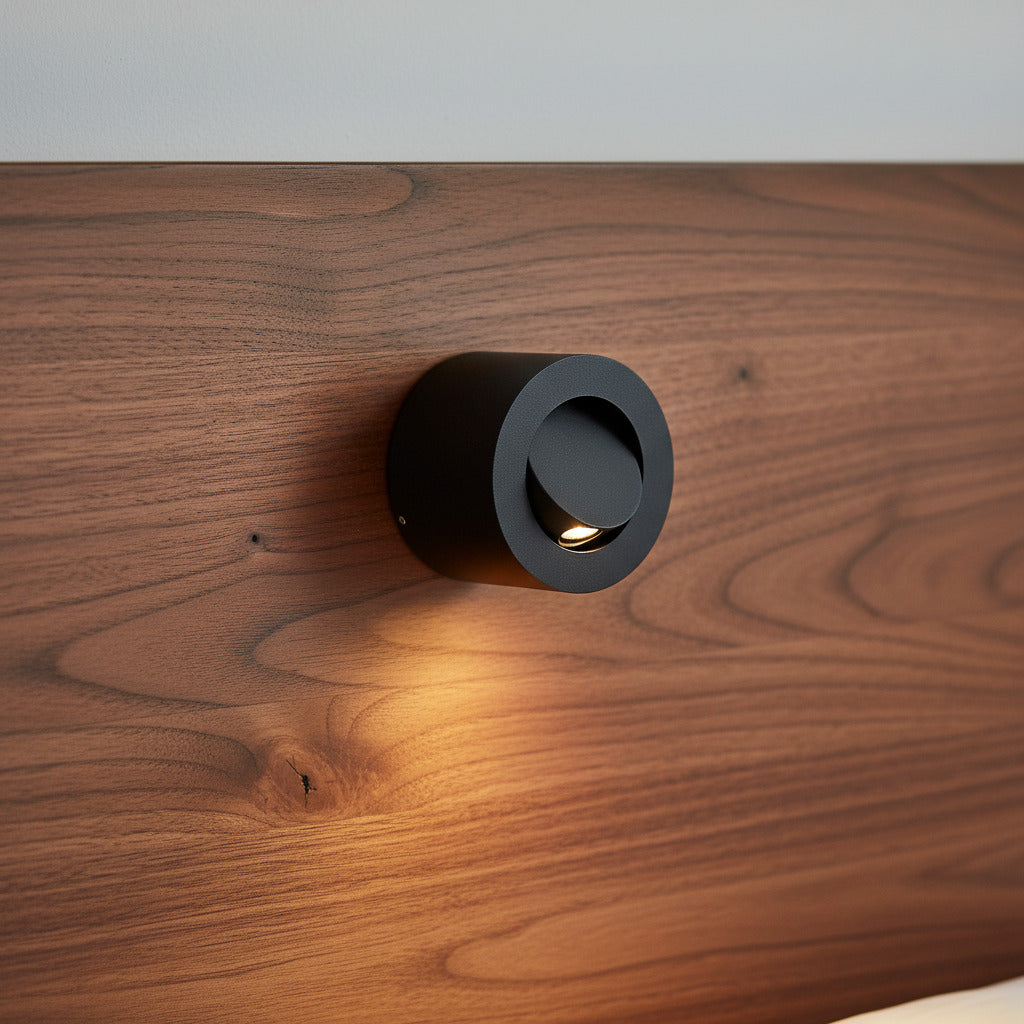 black adjustable bedside light for reading mounted on a wooden headboard