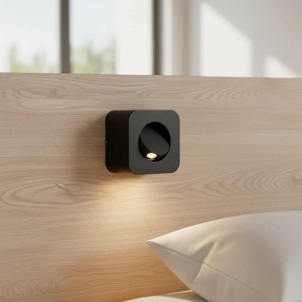 black adjustable bedroom wall reading light mounted on a bed headboard