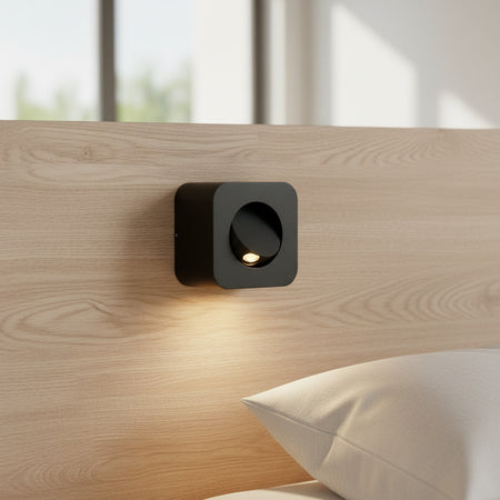 black adjustable bedroom wall reading light mounted on a bed headboard