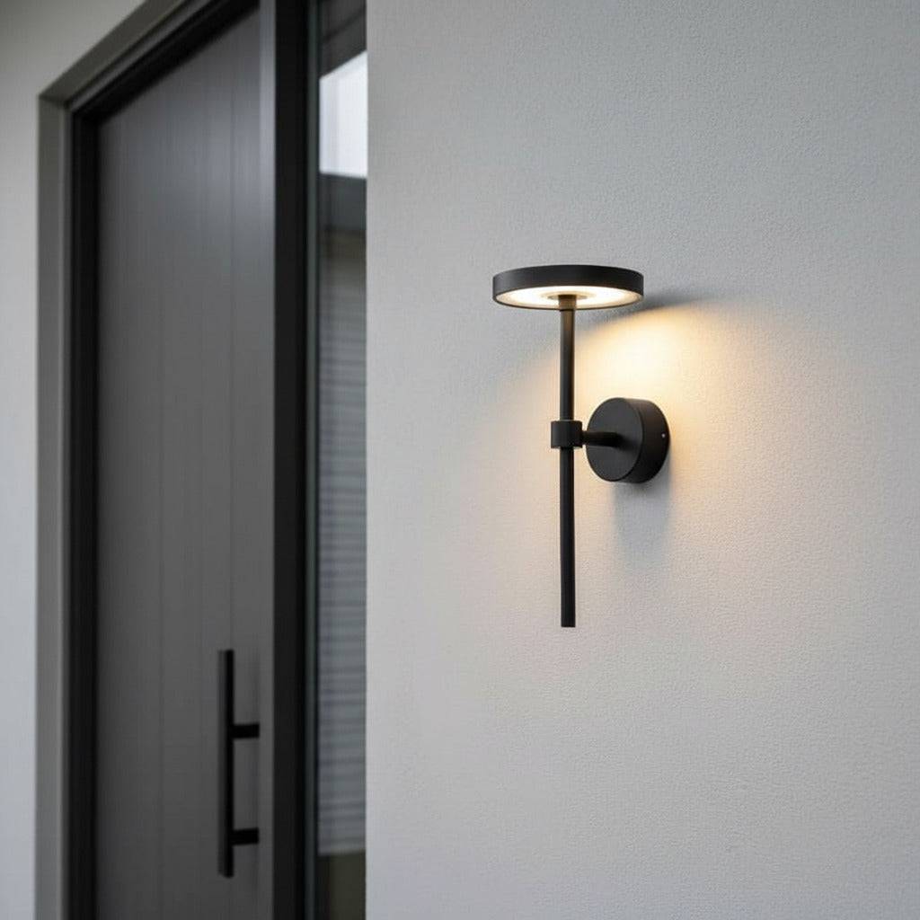 black contemporary external wall light mounted on a white wall next to a house front door 