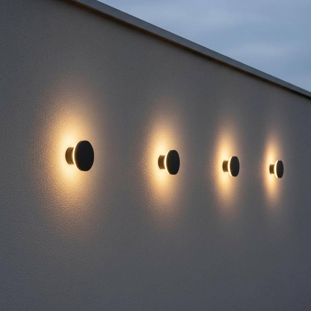 black exterior wall mount light showing 4 lights in a row on a white textured exterior wall 