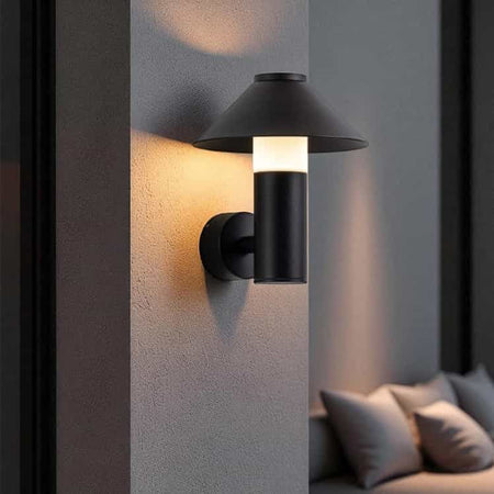 black outdoor lantern light mounted on a white textured wall outside of a modern home