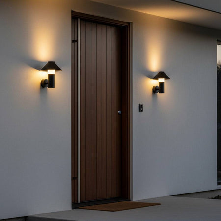 black outdoor lantern light mounted either side of a front door on a white wall 