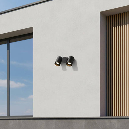 black outdoor wall spotlight mounted on the white wall of a contemporary home 