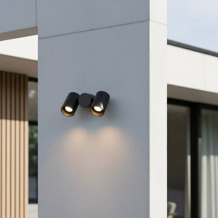 black outdoor wall spotlight mounted on the concrete exterior wall of a building