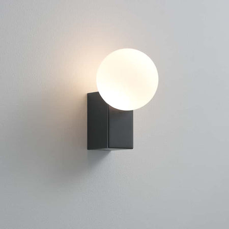 black outdoor wall globe light mounted on a white wall 