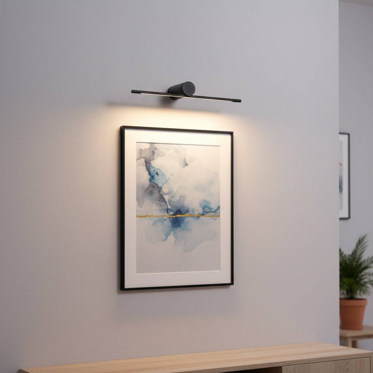 black picture light mounted over artwork on the wall