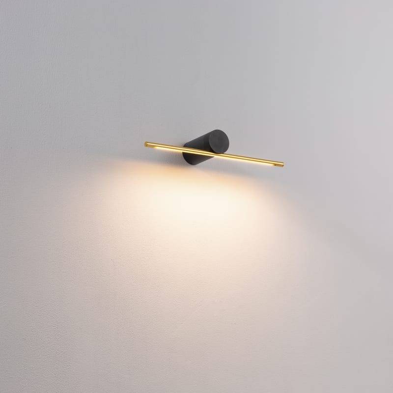 gold small picture light mounted on a grey wall 
