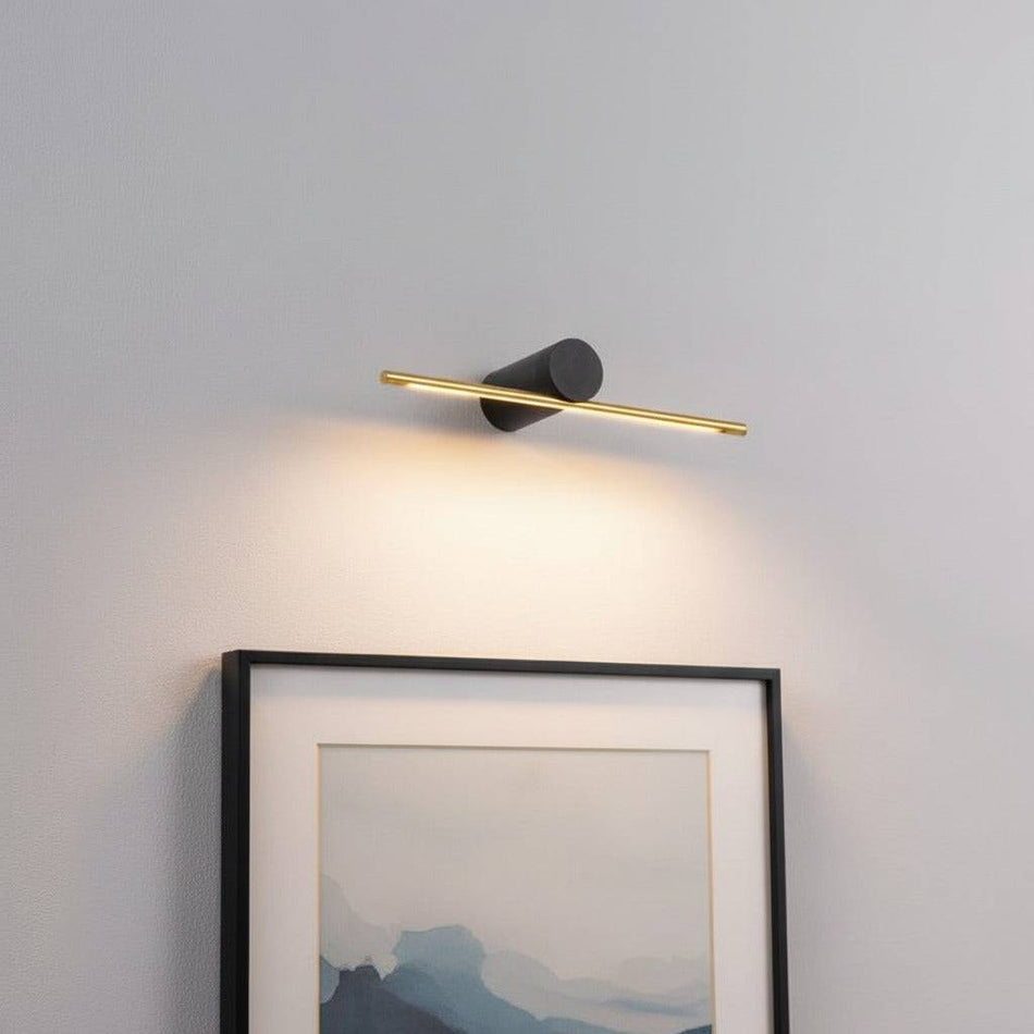 gold small picture light mounted on the wall over a picture