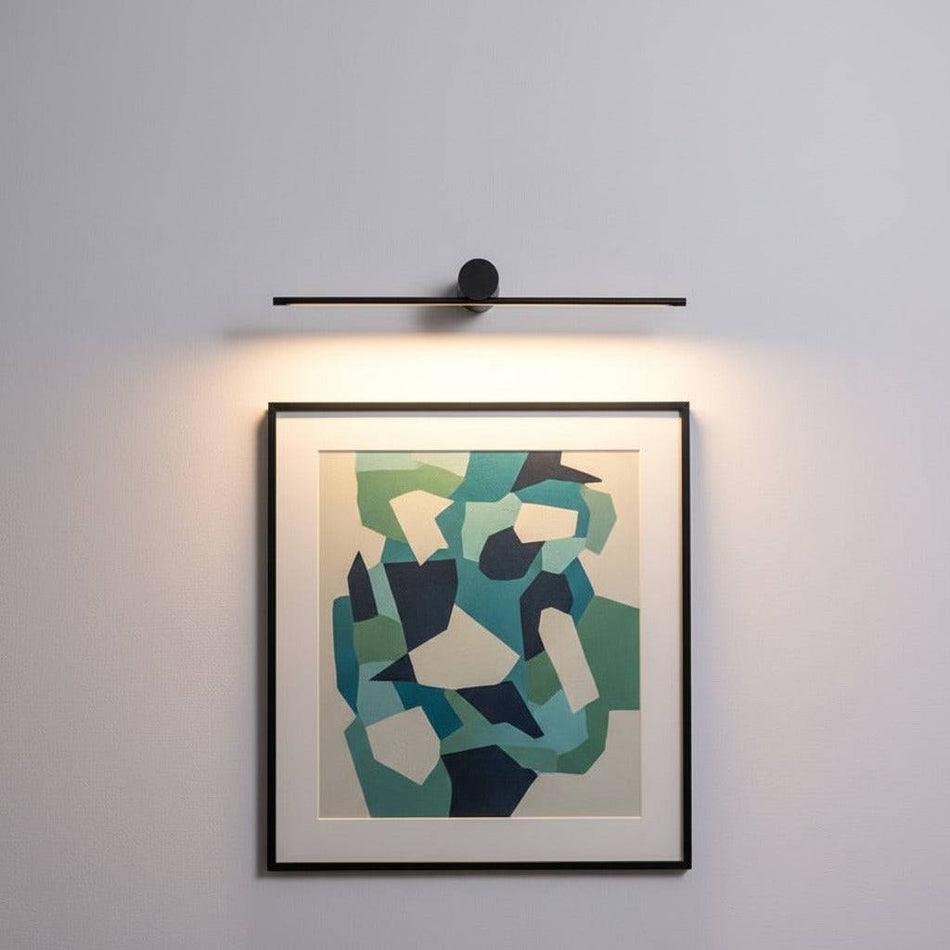 Black over picture light mounted on a white wall over modern artwork 