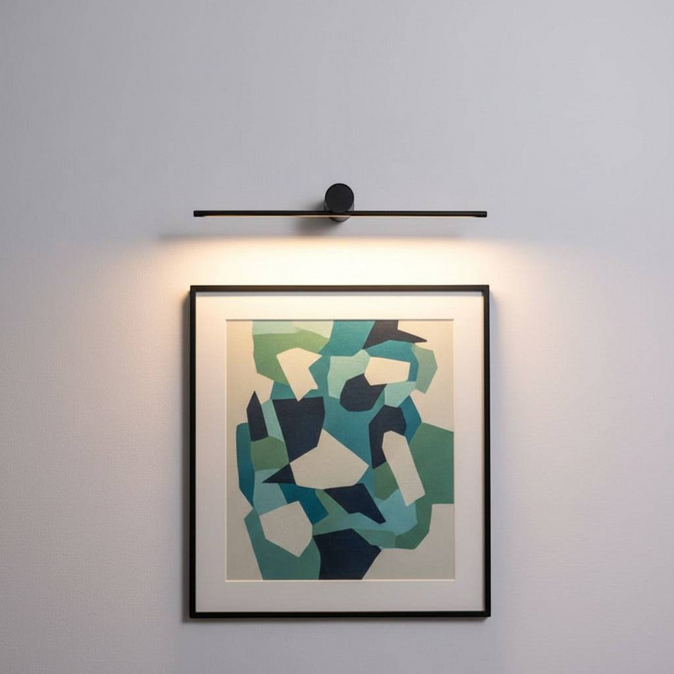 Black over picture light mounted on a white wall over modern artwork