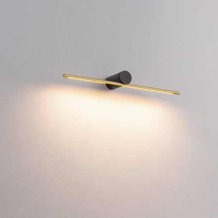 gold picture light fixture mounted on a white wall