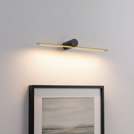 gold picture light fixture mounted over artwork on the wall