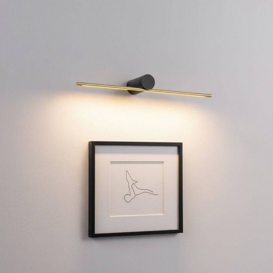 gold picture light fixture mounted on the wall over some modern artwork