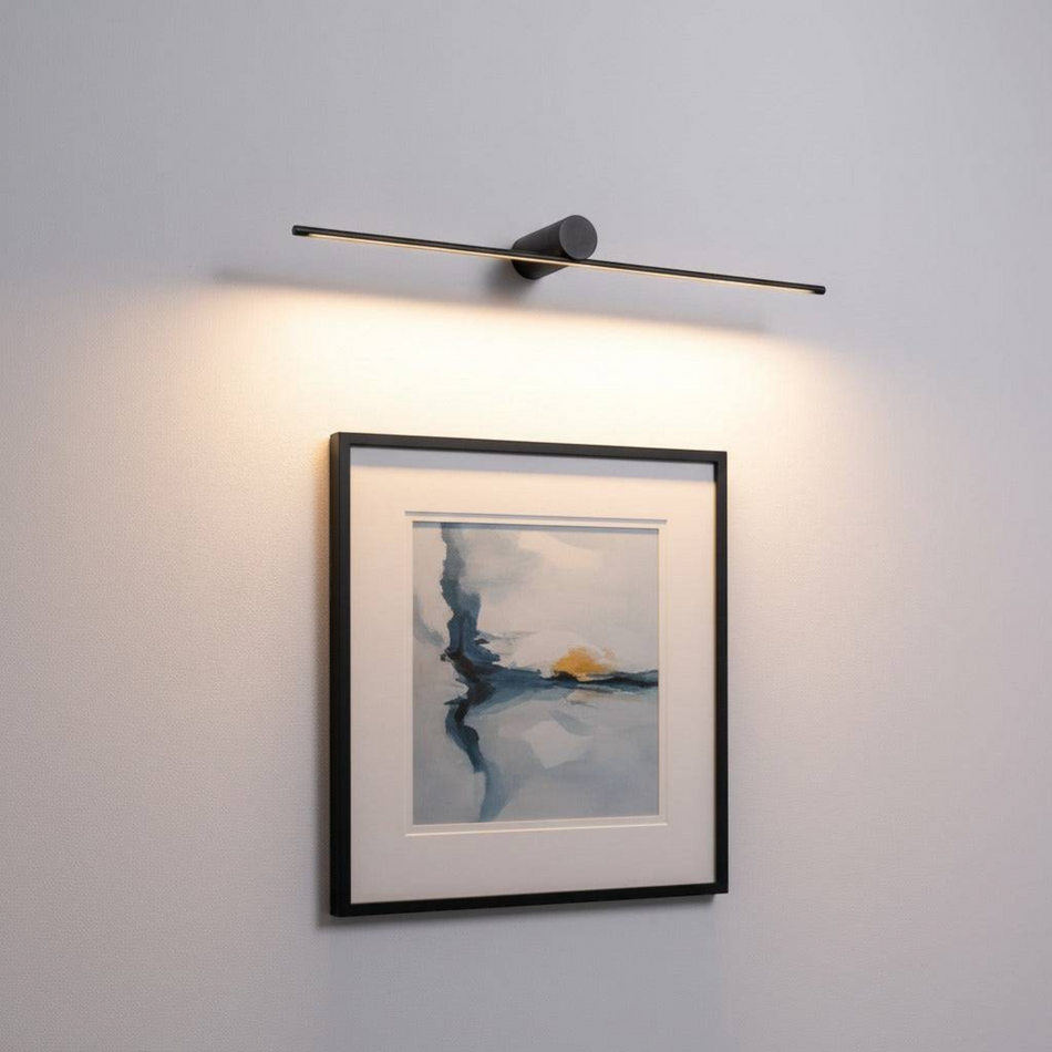 black above picture light mounted on the wall over some artwork