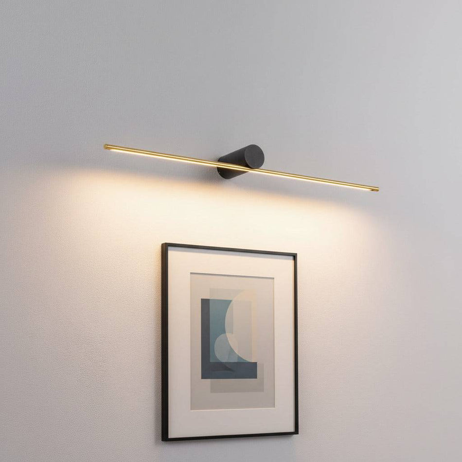 gold led picture lamp mounted over artwork on a wall