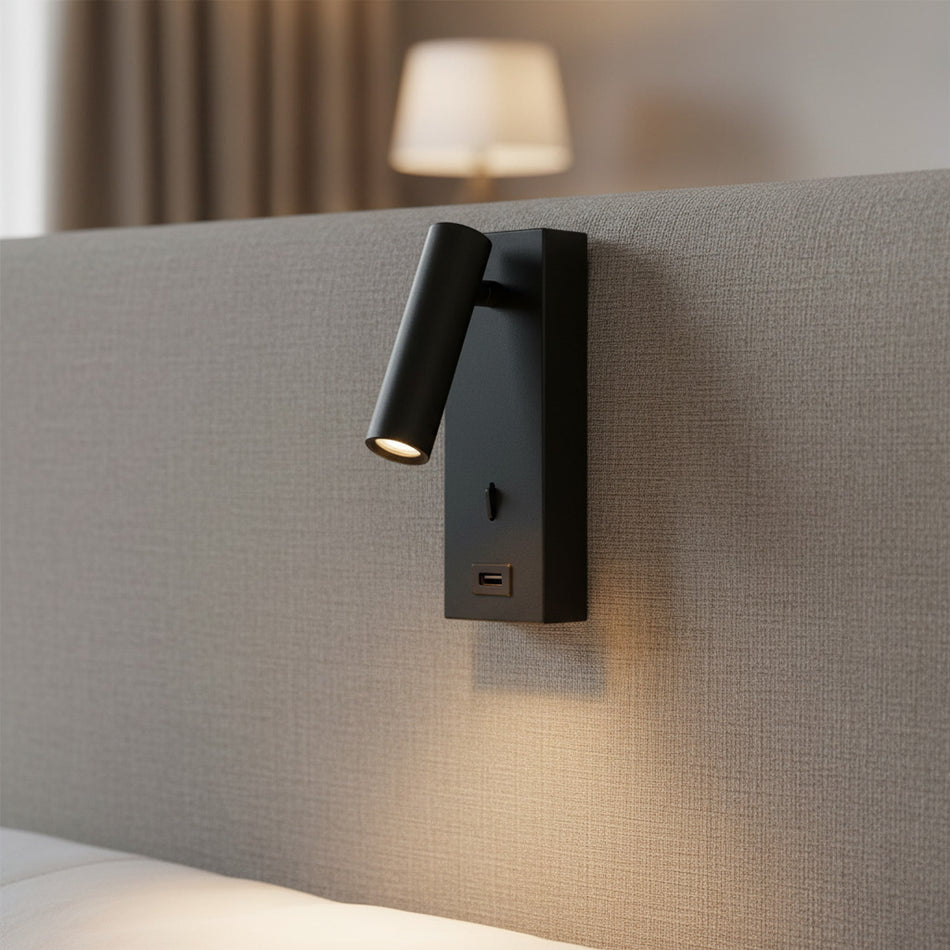 black wall mounted reading light with USB port mounted on a fabric headboard