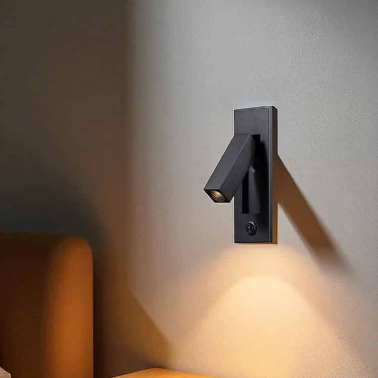 black recessed bedroom reading light mounted on the wall next to a bed 