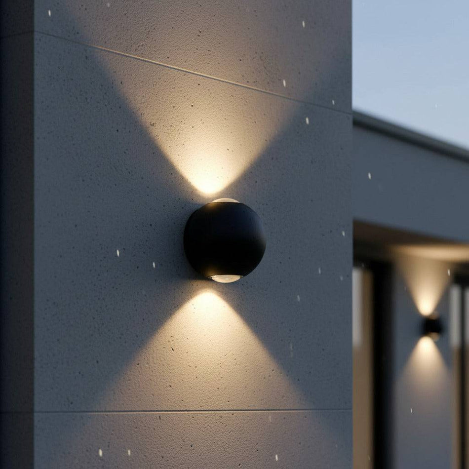 black up and down garden wall light mounted on a concrete wall in the rain on a modern home 