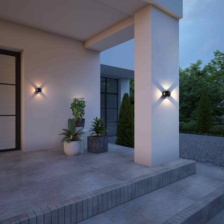 black outside wall light fixture fitted on a white wall outside a modern home covered porch area