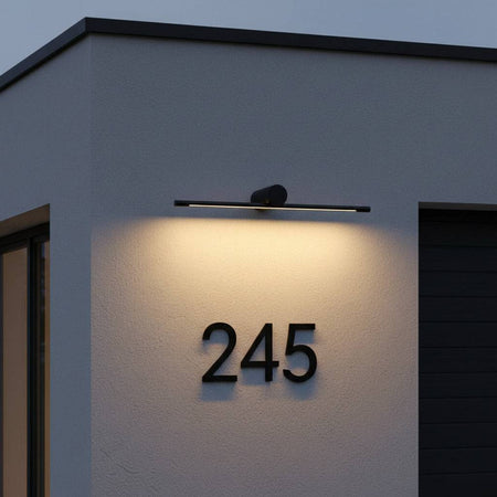 black over sign light shining down to illuminate a house number 